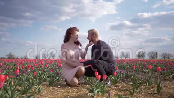 春暖花开之旅孕妇未来的母亲怀着肚子和丈夫一起在花丛中度假视频的预览图