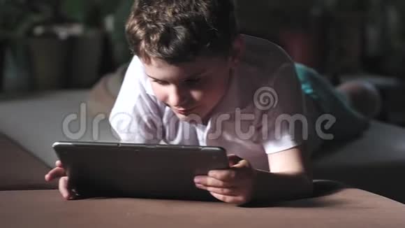 一个穿着t恤的男孩看起来很专注翻阅着照片手指视频的预览图
