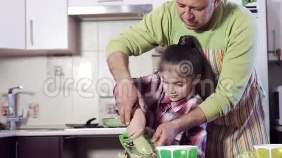 一个女孩在他父亲的指导下篦西葫芦视频的预览图