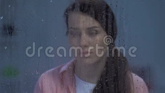 沮丧的女士在雨窗后哭泣离婚后抑郁视频的预览图