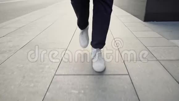 从地面看白色运动鞋沿着人行道慢慢走视频的预览图