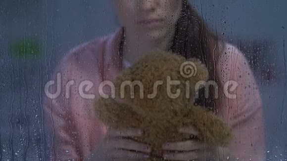 悲伤的女性脸颊上有伤口拥抱着泰迪熊回忆着快乐的童年视频的预览图