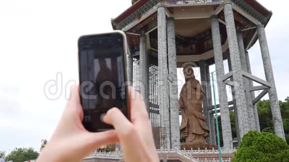 女用智能手机拍摄观音观音或佛寺观音雕像访问精神视频的预览图