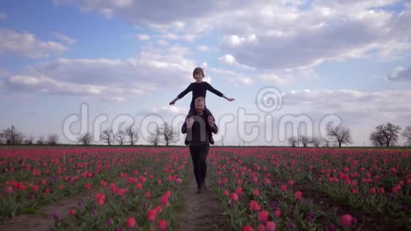 快乐的德国家庭快乐的父亲和欢笑的少年儿子张开双臂坐在肩上到处跑视频的预览图