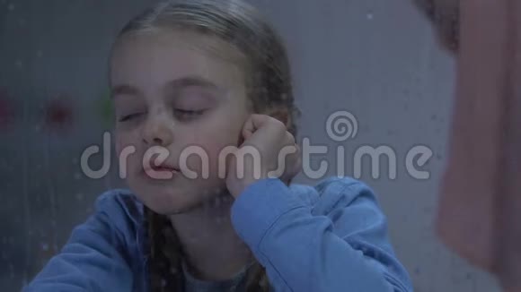 女人对坐在雨窗旁的哭哭啼啼的小女孩大喊大叫孩子受辱视频的预览图