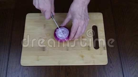 用手在木制砧板上切红甜洋葱做沙拉食物视频的预览图