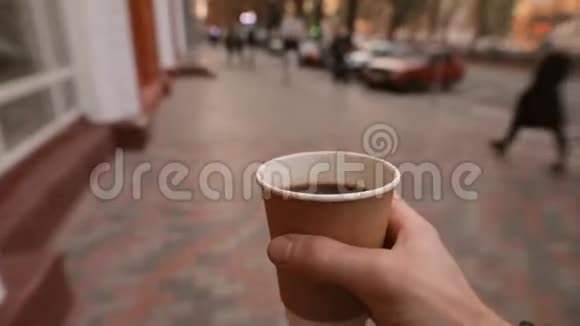 第一人称景观男人端着咖啡杯走在城市大街上视频的预览图