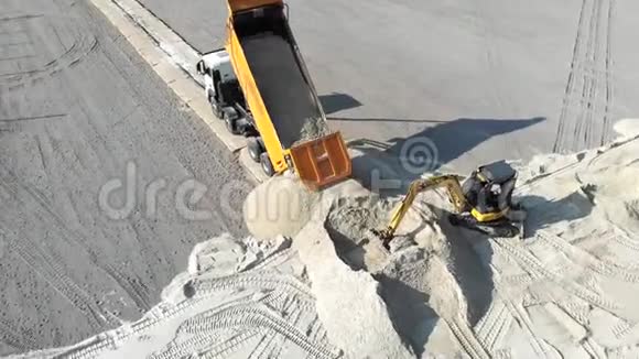 卡车在工地上洒沙子挖掘机铲沙斗视频的预览图