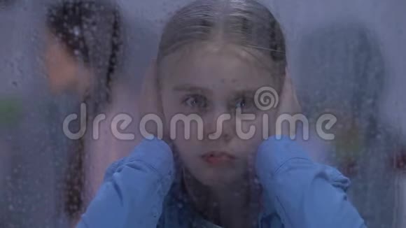 痛苦的女孩在父母发生冲突行为不端时闭上耳朵视频的预览图