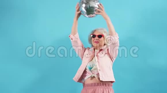 戴墨镜的滑稽老太太拿着球生活方式女人想跳舞视频的预览图