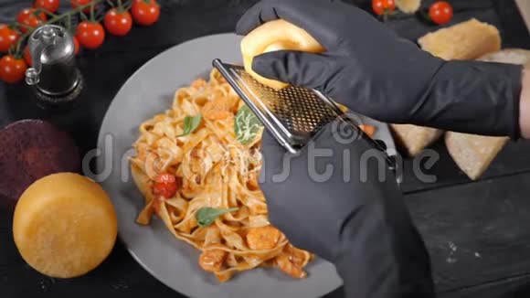 食物视频在克劳运动厨师把奶酪涂在烤架上涂在一盘意大利面上意大利美食奶酪视频的预览图
