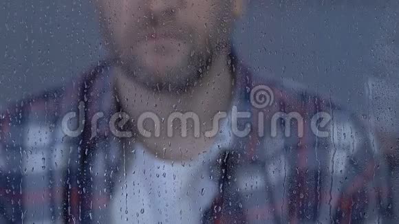 女安慰不幸的男在雨天看窗家庭支持视频的预览图