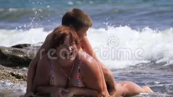 海滩暑假一家人在汹涌的海水中视频的预览图