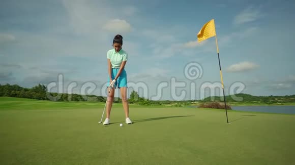 美丽的女孩穿着蓝色短裤打高尔夫在绿色球场练习后泳在炎热的国家度假的美好时光视频的预览图