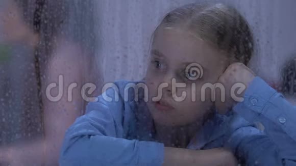 女儿在雨窗里寻找父母在背景上争吵冲突视频的预览图