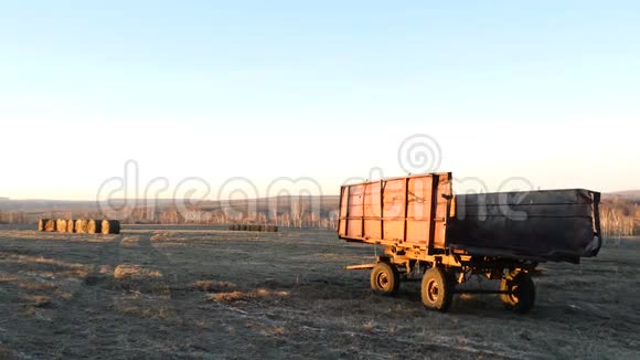 空旷的农田收获后马龙车和海包在田间日落4K射击视频的预览图