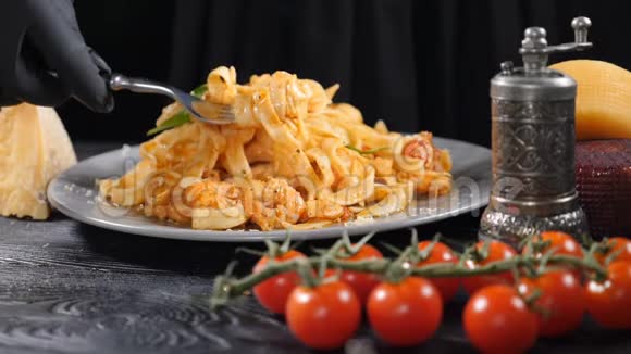 意大利海鲜面食用意大利面扭转叉子带走含樱桃西红柿和奶酪的博洛尼亚面食视频的预览图
