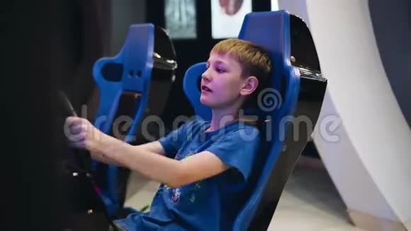 男孩坐在一辆赛车椅子上玩电子游戏从侧面看这个男孩脸上流露出情感视频的预览图