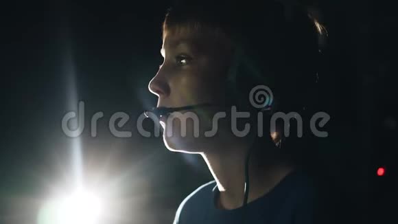 酷男孩玩电子游戏他戴着耳机很棒的录像视频的预览图