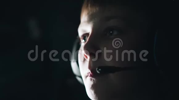 一个头戴耳机的男孩体贴的样子他在玩电子游戏视频的预览图