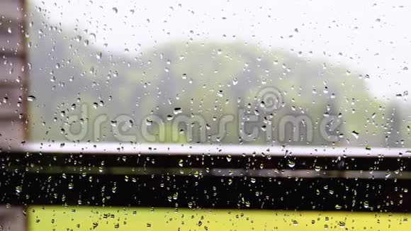 家里一扇塑料窗户玻璃上的雨滴视频的预览图