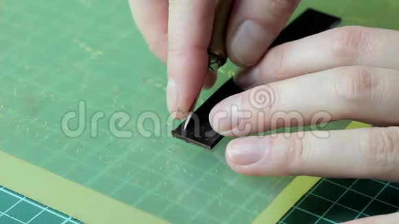 在一个女孩的手中在皮带特写上打洞手工制作视频的预览图
