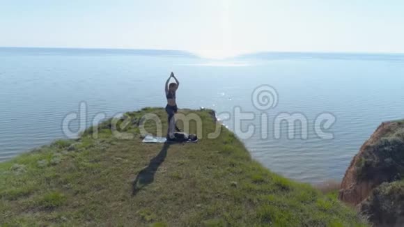 大自然中的瑜伽强壮的瑜伽男性和灵活的女性在海边练习杂技视频的预览图