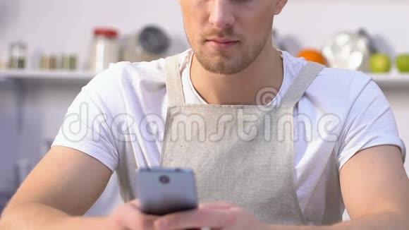 嫉妒的妻子煮咖啡偷看丈夫在智能手机上聊天视频的预览图