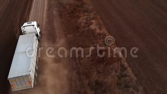 卡车正沿着犁田间的土路行驶视频的预览图