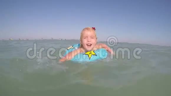 一个金发碧眼的小女孩在水中嬉戏视频的预览图