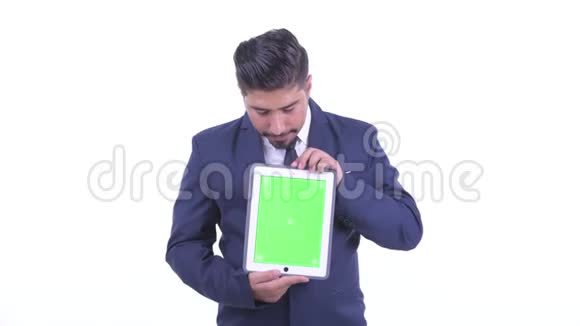 一位留着胡须的波斯商人一边看着数码平板电脑一边思考视频的预览图