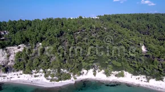 鸟瞰海岸线岩石下有小绿松石滩有树木和建筑物希维里哈尔基迪基希腊向后移动视频的预览图