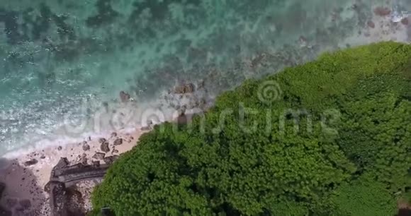 在巴厘岛岩石海岸的顶部蓝色的水和绿色的树木视频的预览图