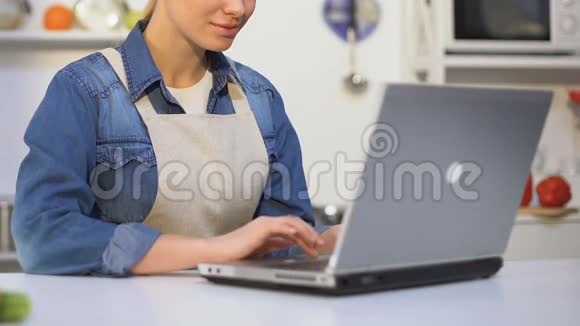 女性烹饪专家在笔记本电脑上打字保留博客提供烹饪技巧视频的预览图