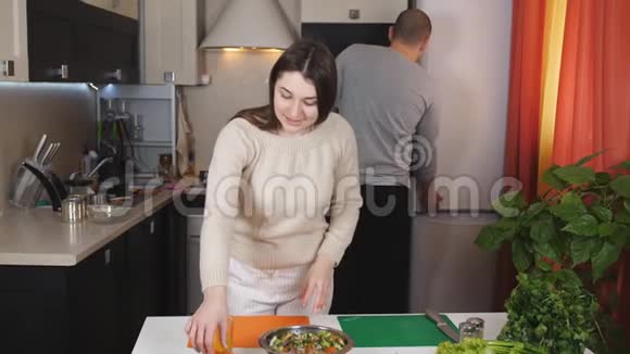 这对夫妇一起做晚饭妻子切蔬菜做沙拉我丈夫倒了一杯橙汁视频的预览图