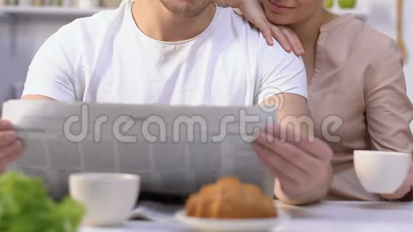 丈夫看早报妻子喝咖啡欣赏生活家人视频的预览图
