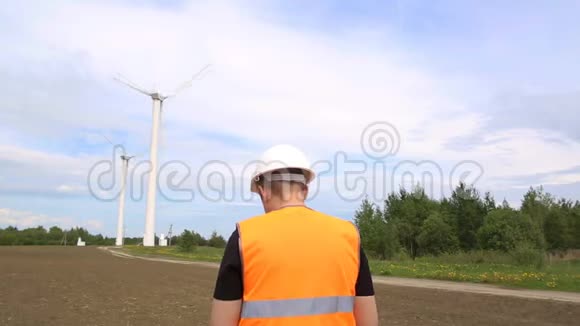 一名男工程师对通过旋转发电的风力涡轮机进行检查视频的预览图