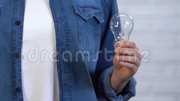 女士手里拿着灯泡在白炽灯和LED灯之间做出选择视频的预览图