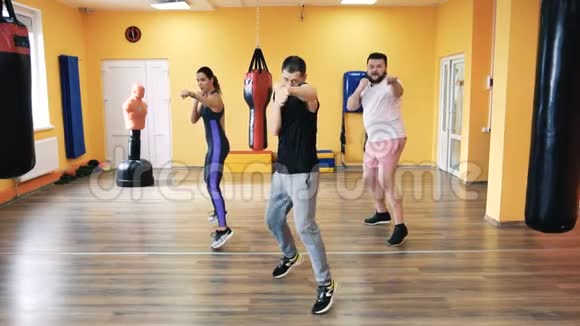 一个丰满的男人和苗条的女孩在健身房里有私人教练在拳击比赛中打火车健康和健身练习与练习视频的预览图