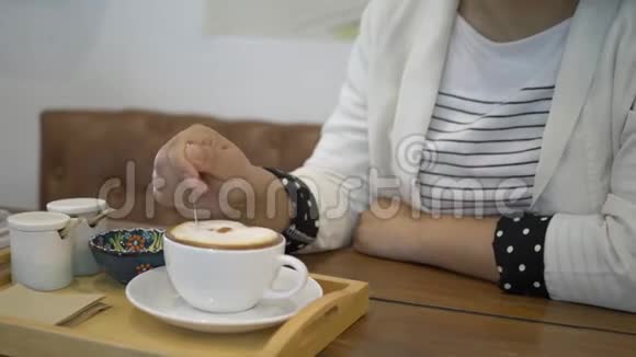 女人一边喝着热咖啡一边坐在咖啡馆里享受它视频的预览图