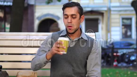 午休时间一位年轻的上班族在城外吃午餐和喝咖啡视频的预览图