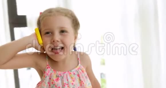 情绪化的女孩在玩具电话上说话视频的预览图