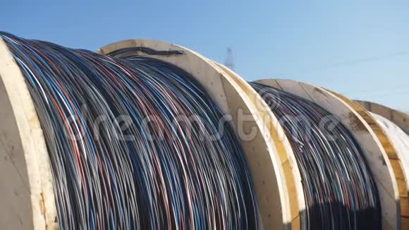 许多巨大的木制线轴在电缆厂的领土上在开阔的天空下有一条厚厚的电缆视频的预览图