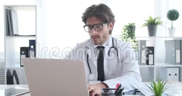 医生在检查X光报告时使用笔记本电脑视频的预览图