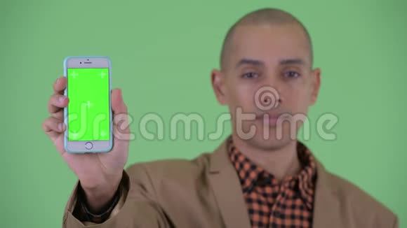 一张严肃的秃顶多民族商人的脸露出电话竖起大拇指视频的预览图