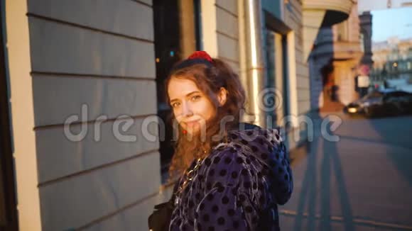 卷曲迷人的女孩微笑看起来很可爱日落时分欧洲城市的年轻美女穿蓝色衣服的女孩视频的预览图
