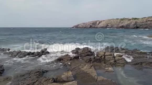 岩石海湾泡沫般的海浪拍打着岩石悬崖和荒野视频的预览图