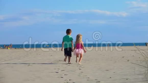 小男孩和小女孩沿着沙滩奔向大海视频的预览图