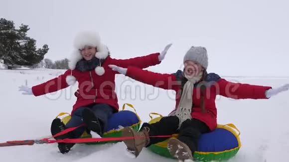 快乐的孩子们在冬天的雪地里雪橇挥手圣诞节期间家庭在冬季公园玩耍视频的预览图