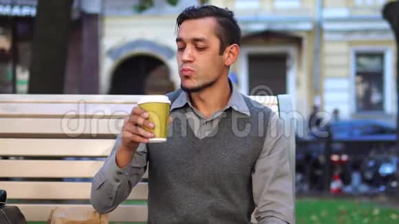 午休时间一位年轻的上班族在城外吃午餐和喝咖啡视频的预览图